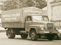 Historic sepia photo of a truck loaded with coffee bags parked in front of a building.