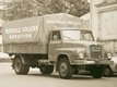 Historic sepia photo of a truck loaded with coffee bags parked in front of a building.