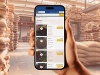 Hand holding a smartphone displaying the V-Hub platform inside a coffee warehouse.