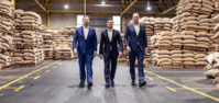 Three directors walking through a warehouse aisle together.