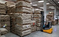 Koffiezakken op pallets worden door een medewerker met een heftruck gestapeld in het magazijn in Napels.