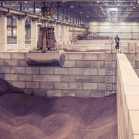 Large warehouse interior where cocoa is stored in bulk between concrete walls.