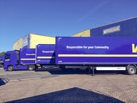Vollers trucks parked side by side in front of a warehouse.