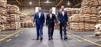 Three directors walking through a warehouse aisle together.